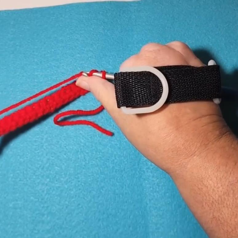 screenshot of Kayla using a hook holder on one hand to crochet