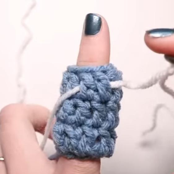 a crochet tube around a finger with yarn running through it